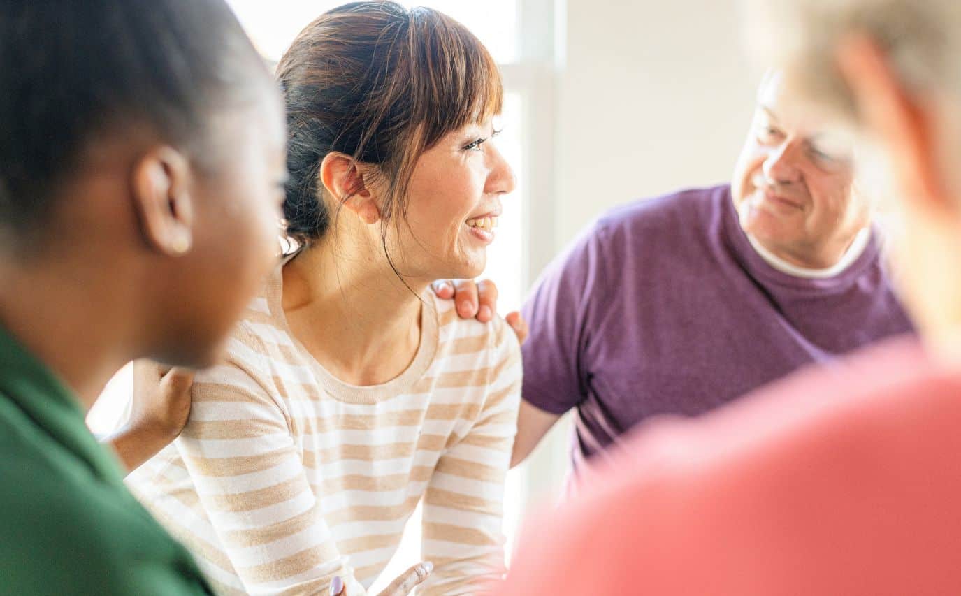 Woman attending a support group focused on sobriety vs recovery.