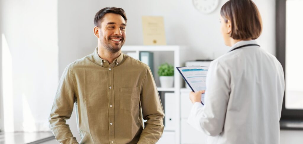 A man discusses detox vs rehab with a professional during an evaluation.