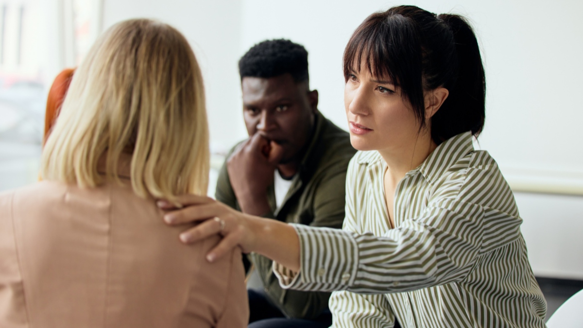 A woman is comforted after sharing her story during relapse prevention therapy in Mississippi