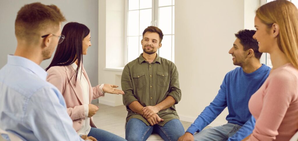 People discussing 'How long does drug withdrawal last?' during a group therapy.