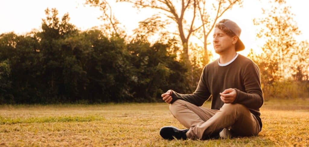 Man meditating outdoors at our rehab in Mantachie, MS.