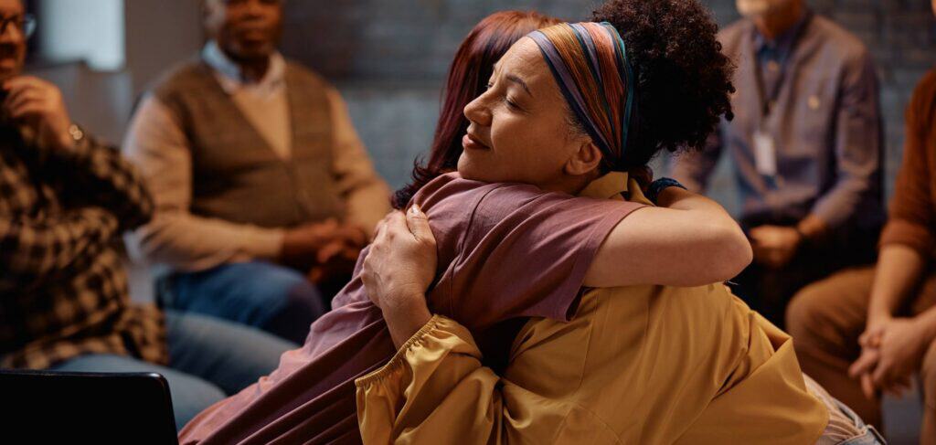 Women sharing a supportive hug in sober living in Mississippi.